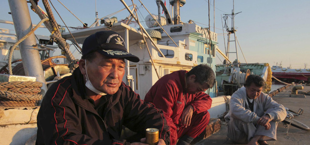 Pescadores de la provincia de Iwaki junto al barco en el que ahora viven. | AP