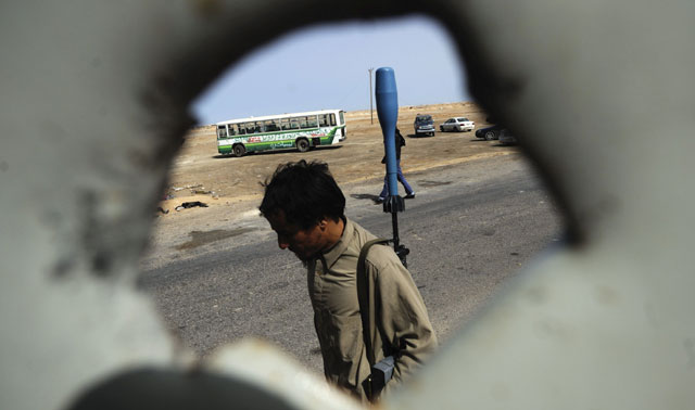 Un rebelde libio armado camina por una de las zonas de enfrentamientos. | Efe