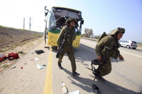 Soldados israeles permanecen en la zona donde el autobs fue atacado. | Efe