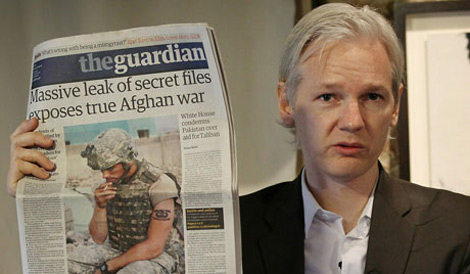 Julian Assange ensea un ejemplar de 'The Guardian'. | Peter Macdiarmid/Getty Images