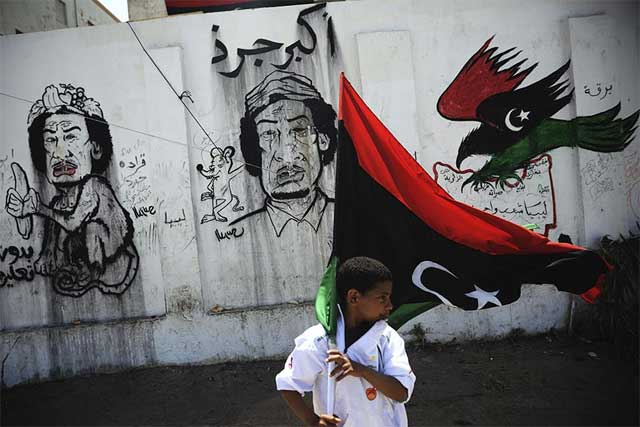 Un nio libio sostiene una bandera pre-Gadafi en Bengasi.| Efe