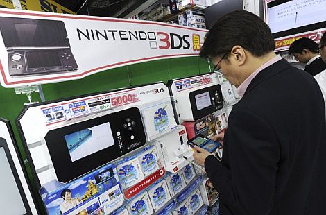 Un cliente prueba la Nintendo 3DS en una tienda de Tokio. | Efe