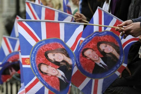 Banderas con la imagen de los novios en Londres. | Reuters