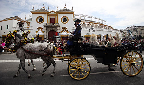 Un carruaje pasa ante la plaza de toros de la Maestranza. | Fernando Ruso