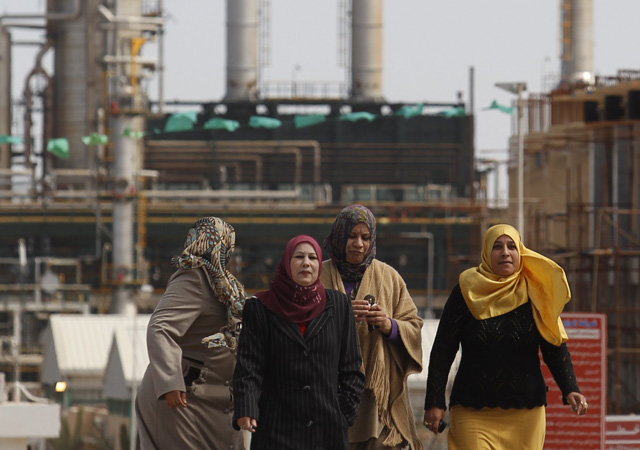 Mujeres libias caminan junto a la refinera de petrleo en Zawiya. | Reuters
