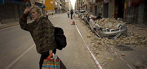 Una lorquina camina por una de las calles donde son evidentes los daos. | AFP