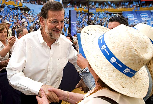 Rajoy saluda a una de las simpatizantes del PP en el acto de Zaragoza. | Efe/Diego Crespo