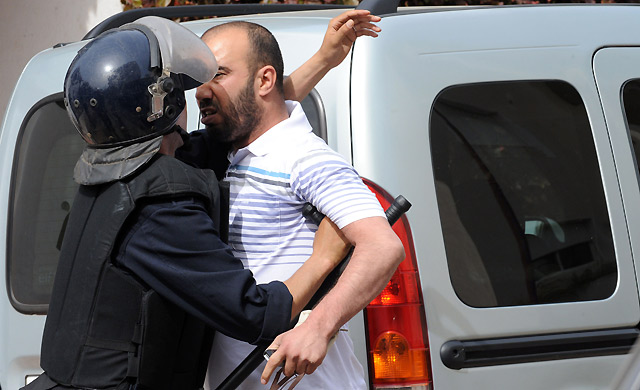 Un manifestante del 20 de Febrero se enfrenta a un polica. | Afp