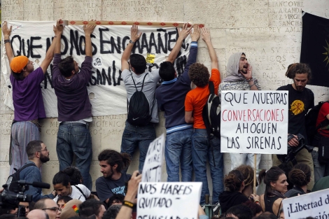 Un grupo de jóvenes cuelgan una pancarta en la Puerta del Sol. | J. Barbancho