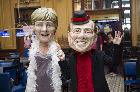 Activistas disfrazados del primer ministro italiano, Silvio Berlusconi, y la canciller alemana, Angela Merkel, en una accin crtica de la ONG Intermon Oxfam. | Afp