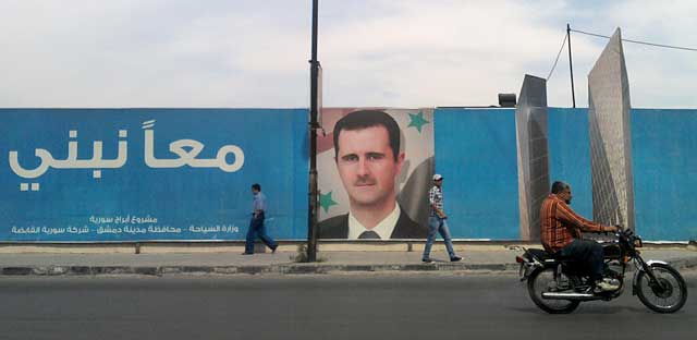 Una imagen del jefe de Estado sirio, Bashar Asad, en una calle de Damasco. | AP
