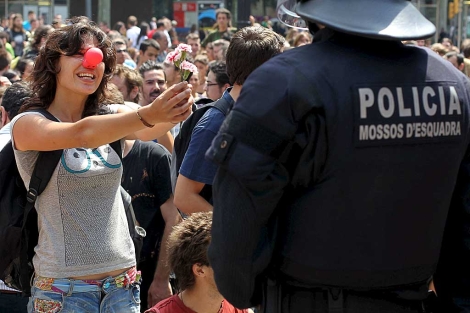 Una joven ofrece claveles a un 'mosso' en la plaza de Catalua. | Efe