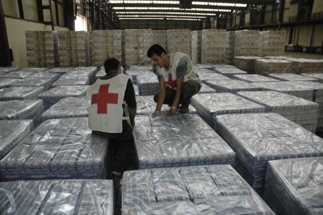 Dos voluntarios de la Cruz Roja preparan decenas de paquetes de alimentos.| Patxi Corral