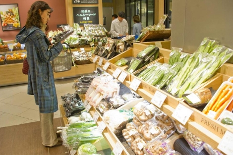 Una mujer examina alimentos en un mercado.| Efe