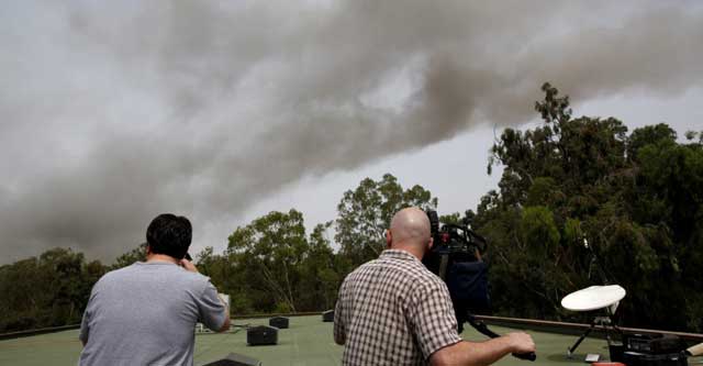 Reporteros graban la columna negra sobre Trípoli. | Reuters