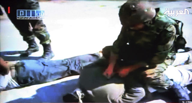 Imagen de una emisión de la televisión Al Arabiya de un soldado sirio subido sobre un hombre en Homs. | Efe