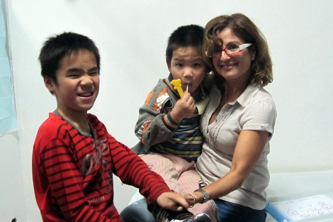 Blanca Rudilla, gerente de la Asociación para el Cuidado de la Infancia, con dos niños.