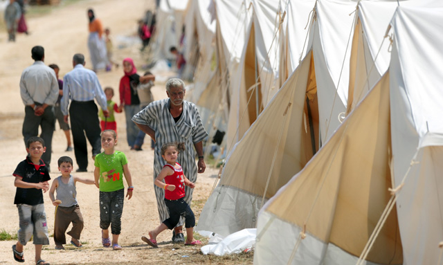 Refugiados caminan entre las tiendas del campamento de Altinz.| Mustafa Ozer/AFP Photo