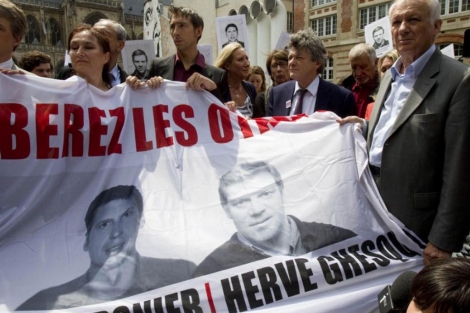 Dos diputados franceses y el hermano de Taponier con pancartas de apoyo. | Reuters