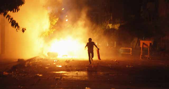 Un manifestante intenta escapar del fuego de un cctel molotov en El Cairo. | Reuters