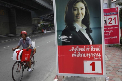 Un hombre pasa junto a un cartel electoral de Yingluck Shinawatra. | Ap