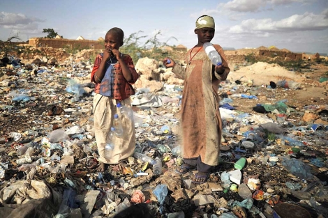Dos niños somalíes entre la basura en las cercanías de un campo de refugiados. | Afp