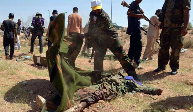 Rebeldes libios cubren el cuerpo de un soldado en Gualish, Libia. | Afp