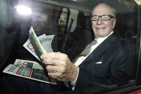 Rupert Murdoch lee una copia de 'The Sun' y 'The Times'. | Reuters