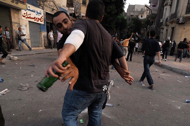 Un manifestante se enfrenta a un hombre que le amenaza con una botella con botellas. | Efe