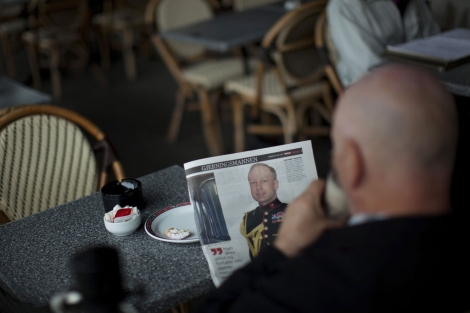 Un hombre lee una noticia sobre el autor de la matanza en Noruega. | Ap