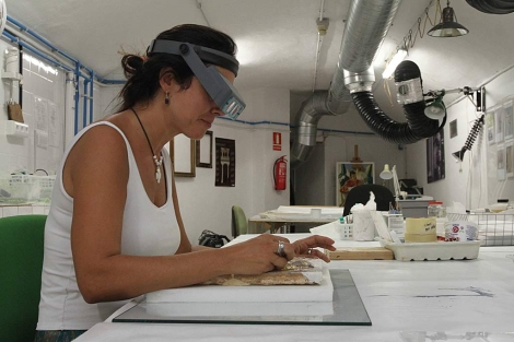 Una restauradora del museo trabaja en un azulejo procedente de una donacin. | C. M.