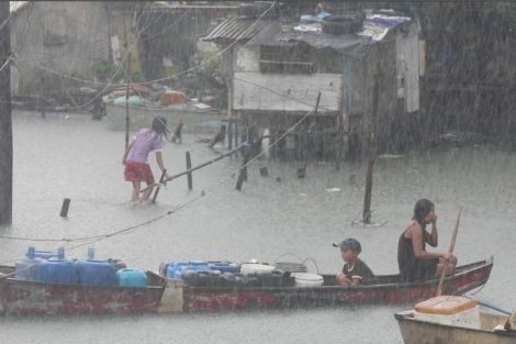 Filipinos recorren las vas inundadas tras el paso del tifn Nock-Ten. | Efe