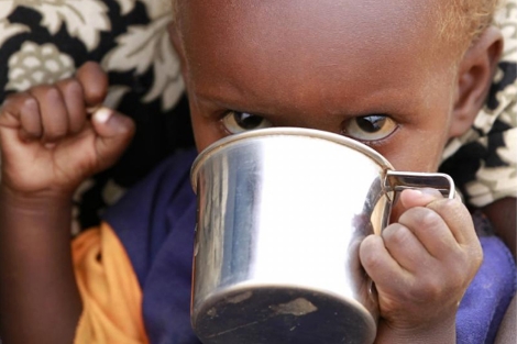 Un nio somal recibe alimentos en un campo de refugiados.| Reuters