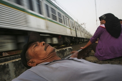 Un hombre sigue la 'terapia del tren' en Yakarta. | Ap