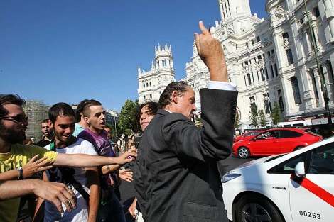 Un hombre hace un gesto a un grupo de 'indignados' que cortaban el trfico en Madrid. | Efe