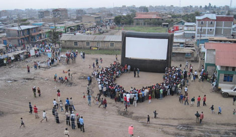 En el poblado de Kiberia se renen en torno a la pantalla. | Hot Sun Foundation