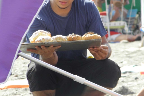 Un joven vende pasteles en la playa. | ELMUNDO.es