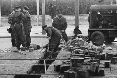 Un grupo de militares prepara el pavimento para levantar el muro en 1961. | Ap