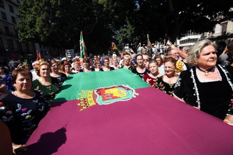 Mujeres portan la bandera de Málaga en la romería. | Jesús Domínguez
