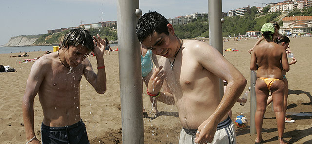 Jvenes bandose en las duchas de una playa de Getxo. | Mitxi