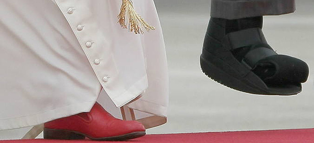 La bota ortopdica del Rey contrasta con el zapato rojo de Prada del Papa.