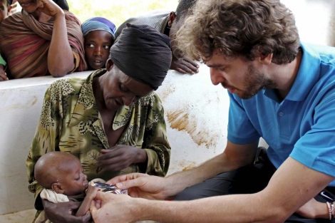 Pau Gasol ayuda a dar de comer a un beb durante un viaje a Etiopa en 2010.| EFE