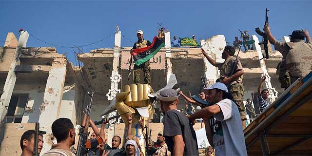 Un grupo de rebeldes celebran en Bab el Aziziya. | Reuters MS IMGENES
