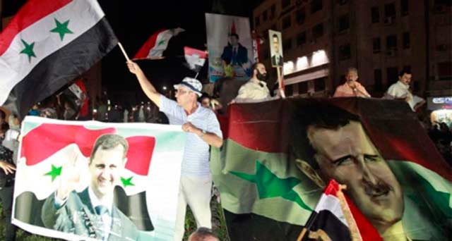 Manifestantes en apoyo de Assad en el centro de Damasco. | Efe