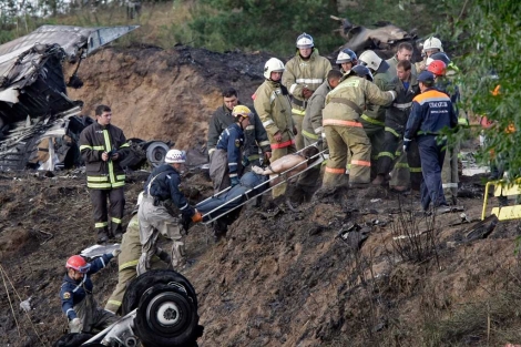 Las autoridades cargan con los cuerpos inertes tras el accidente en Rusia. | AP