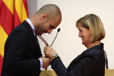 Guardiola recibe la medalla de manos de la presidenta del Parlament. | Reuters