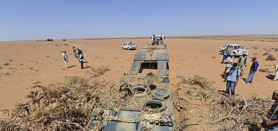 Combatientes rebeldes libios desentierran vehculos militares en Dufan. | Efe