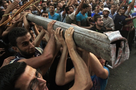 Un grupo de manifestantes trata de hacer caer el muro. | Reuters