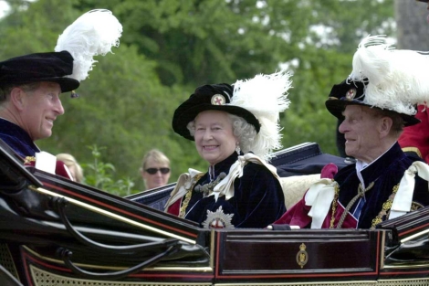 La reina de Inglaterra rodeada por el prncipe de Gales y el principe de Edimburgo. | AFP