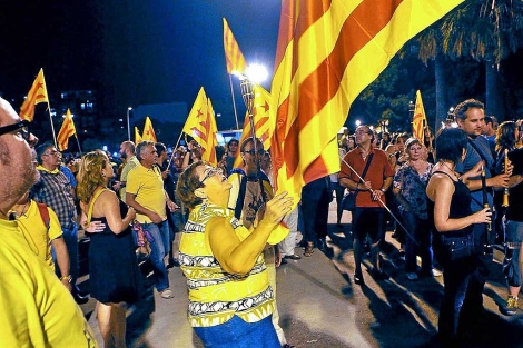 Una mujer sostiene una bandera catalana independentista en Badalona. | Santi Cogolludo